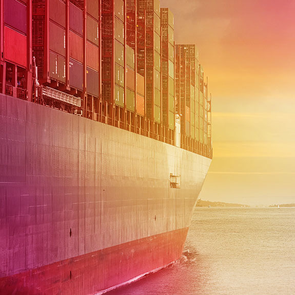 A massive container ship sails across the vast ocean, carrying goods and traversing the open waters.